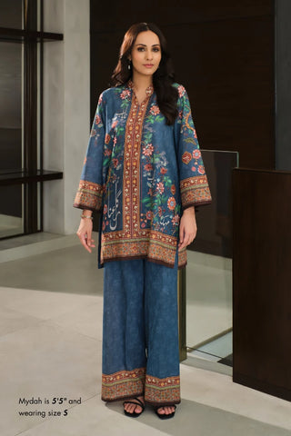 Woman wearing a traditional outfit with floral patterns in a modern setting
